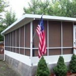 custom screen room built onto a mobile home with large American flag