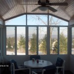 sunroom with wooden ceiling and fan and great view of woods