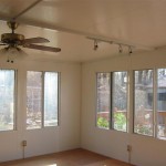 sun room with ceiling fan and custom lighting fixtures installed