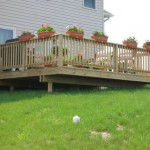 custom deck installed in backyard with potted plants