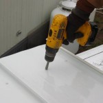 contractor using drill to attach new roof to mobile home